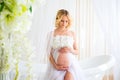 Beautiful pregnant in light white lace negligee in the bathroom Royalty Free Stock Photo