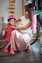 Beautiful pregnant mother to shopping new helmet for her girl in bike shop Royalty Free Stock Photo