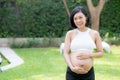 Beautiful pregnant of portrait asian young woman relax in the park, girl with belly standing on grass Royalty Free Stock Photo