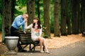 Beautiful pregnant stylish couple relaxing outside in the autumn park sitting on bench. Royalty Free Stock Photo