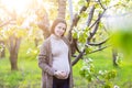 Beautiful pregnant woman in blooming garden