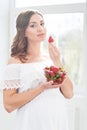 Beautiful pregnant woman with a bowl of strawberries Royalty Free Stock Photo