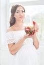 Beautiful pregnant woman with a bowl of strawberries Royalty Free Stock Photo