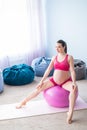 Beautiful pregnant woman doing exercises on a fitness ball. Expectant mother in the last trimester doing yoga. Royalty Free Stock Photo