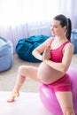 Beautiful pregnant woman doing exercises on a fitness ball. Expectant mother in the last trimester doing yoga. Royalty Free Stock Photo