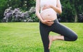 Beautiful pregnant woman doing prenatal yoga on nature outdoors. Royalty Free Stock Photo