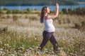 Beautiful pregnant woman doing sports in the camomile field Royalty Free Stock Photo