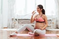 Beautiful pregnant woman excercising in a bright room