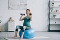 beautiful pregnant woman exercising with dumbbells on fitness ball Royalty Free Stock Photo