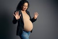 Beautiful pregnant woman expecting a baby, showing number nine with her fingers, 9 month of happy carefree pregnancy