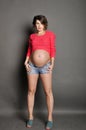 Beautiful pregnant woman on gray background in studio