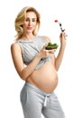 Beautiful pregnant woman hold organic salad and fork with tomato. Pregnancy motherhood expectation healthy eating Royalty Free Stock Photo