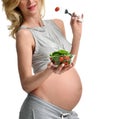 Beautiful pregnant woman hold organic salad and fork with tomato. Pregnancy motherhood expectation healthy eating Royalty Free Stock Photo