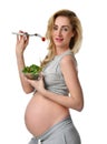 Beautiful pregnant woman hold organic salad and fork with tomato. Pregnancy motherhood expectation healthy eating Royalty Free Stock Photo
