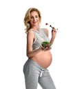 Beautiful pregnant woman hold organic salad and fork with tomato. Pregnancy motherhood expectation healthy eating Royalty Free Stock Photo