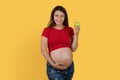 Beautiful pregnant woman holding green apple and smiling at camera Royalty Free Stock Photo