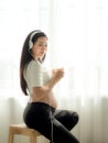 Beautiful pregnant women listen to music from headphones and drink soy milk Royalty Free Stock Photo