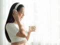 Beautiful pregnant women listen to music from headphones and drink soy milk Royalty Free Stock Photo