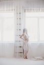 Beautiful pregnant woman with long hair standing near window Royalty Free Stock Photo