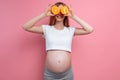 Beautiful pregnant woman with orange fruit