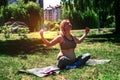 Beautiful pregnant woman practicing yoga in summer park. Beautiful pregnant woman sitting on grass Royalty Free Stock Photo