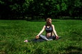 Beautiful pregnant woman practicing yoga in summer park. Beautiful pregnant woman sitting on grass Royalty Free Stock Photo