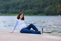 Beautiful pregnant woman relaxing at a river shore