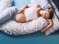 Pregnant woman relaxing or sleeping with belly support pillow in bed. Pregnancy concept Royalty Free Stock Photo