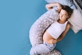 Pregnant woman relaxing or sleeping with belly support pillow in bed. Pregnancy concept Royalty Free Stock Photo