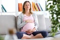 Beautiful pregnant woman relaxing on the sofa at home