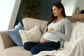 Beautiful pregnant woman resting on sofa at home Royalty Free Stock Photo