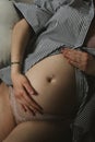 a pregnant woman lays on the couch and holds her belly Royalty Free Stock Photo
