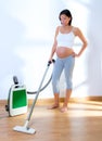 Beautiful pregnant woman retro vacuum housewife