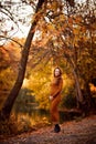 Pregnant in slinky dress in autumn Park by river. Royalty Free Stock Photo