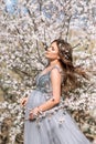 Beautiful pregnant woman in a smart dress in a blooming spring garden Royalty Free Stock Photo