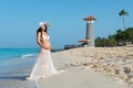 Beautiful pregnant woman standing on a sandy beach with palm trees on a lighthouse background. Caribbean Sea. Royalty Free Stock Photo