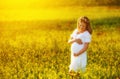 Beautiful pregnant woman in summer nature meadow with yellow flo Royalty Free Stock Photo