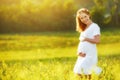 Beautiful pregnant woman in summer nature meadow with yellow flo Royalty Free Stock Photo