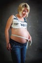 Beautiful pregnant woman tenderly measuring her tummy Royalty Free Stock Photo