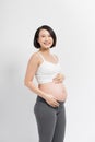 Beautiful pregnant woman touching her belly with hands on a white background Royalty Free Stock Photo