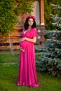 Beautiful pregnant woman touching her belly wearing in pink dres Royalty Free Stock Photo