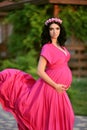 Beautiful pregnant woman touching her belly wearing in pink dres Royalty Free Stock Photo