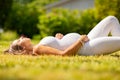 Beautiful pregnant woman in white clothes laying on grass Royalty Free Stock Photo