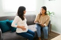 Pregnant woman and latin midwife talking about the due date Royalty Free Stock Photo