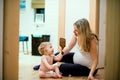 Beautiful pregnant woman sitting with a toddler boy on the floor at home. Royalty Free Stock Photo