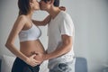 Loving couple expecting baby kissing at home Royalty Free Stock Photo