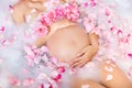 Beautiful pregnant young woman caring her belly in bubble bath with roses flowers