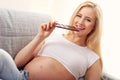 Beautiful pregnant young woman eating chocolate at home Royalty Free Stock Photo