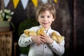 Beautiful preschool child, boy, playing with ducklings at home
