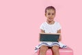 Beautiful preschool little girl holding a board. Empty space for text. School lessons. Back to school. Pink backgrounds